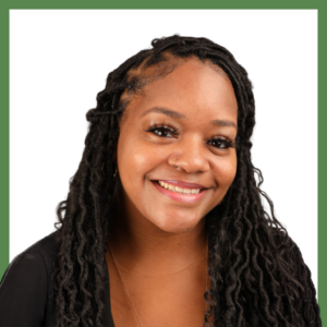 A person with long braided hair and a nose ring smiles warmly at the camera. They are wearing a black top, and the background is plain white with a green border.