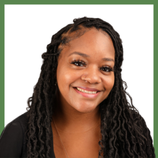 A person with long braided hair and a nose ring smiles warmly at the camera. They are wearing a black top, and the background is plain white with a green border.