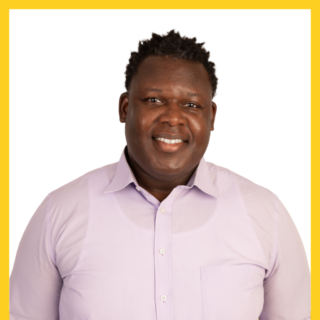 Smiling person wearing a light purple shirt. They are centered in the image with a yellow border. The background is plain white.