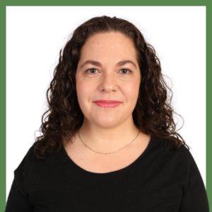 A woman with curly brown hair and wearing a black shirt is smiling gently at the camera against a plain white background framed by a green border.