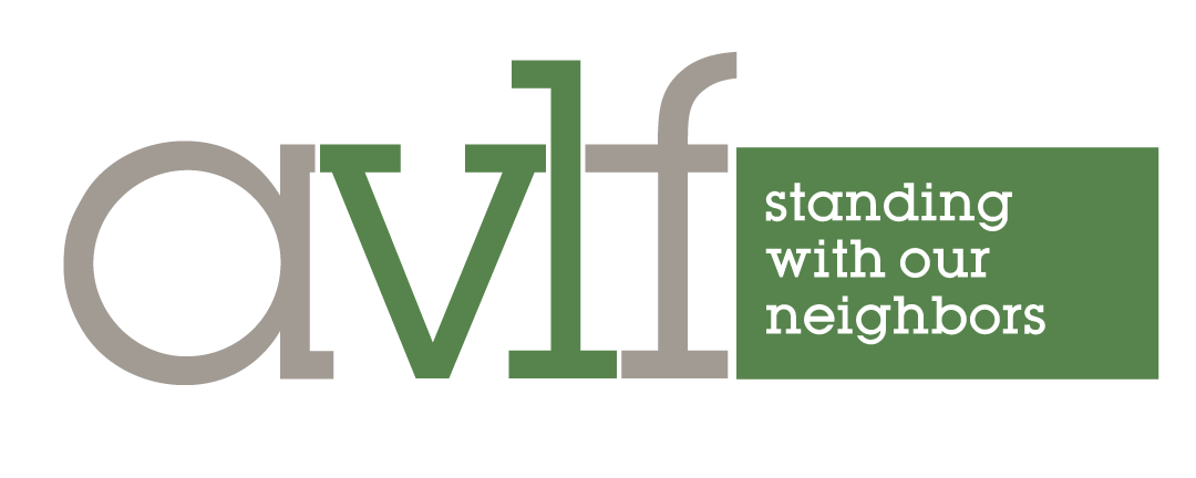 The image shows the AVLF logo with the letters "a v l f" in lowercase, followed by the phrase "standing with our neighbors" in white text inside a green rectangle.