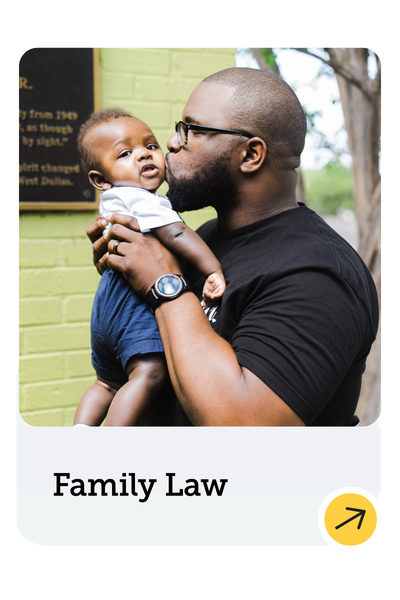 A man wearing glasses and a black shirt kisses a smiling baby on the cheek while holding the child outdoors. The text below reads "Family Law" with a yellow arrow icon.