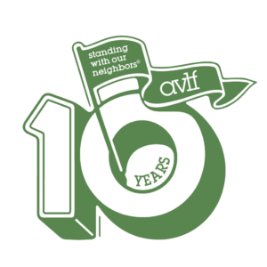 Green and white graphic showing the number "10," with "years" inside the zero. A waving flag reads "standing with our neighbors® AVLT." The design marks a 10-year anniversary.