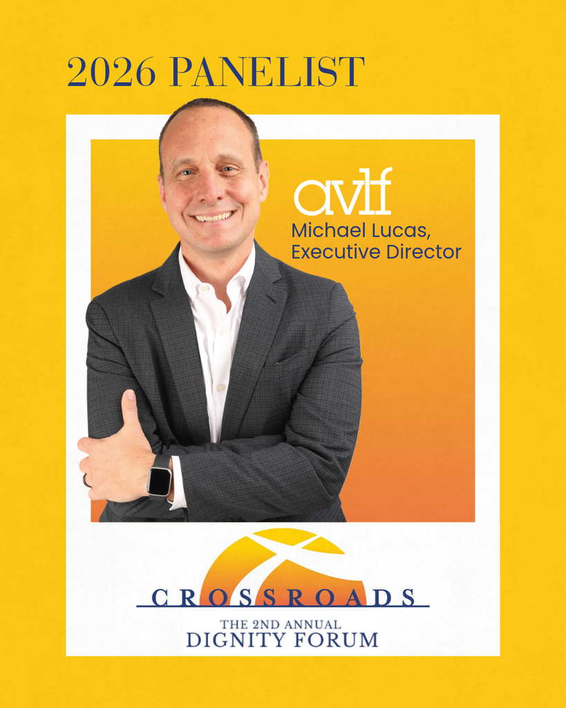 A man in a suit smiles with arms crossed. Text: “2026 Panelist, AVLF Michael Lucas, Executive Director, Crossroads: The 2nd Annual Dignity Forum” on a yellow background with an orange logo.